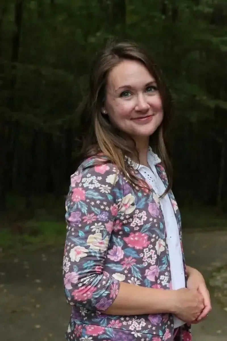Maroon floral print fabric with botanical garden theme on a woven base.