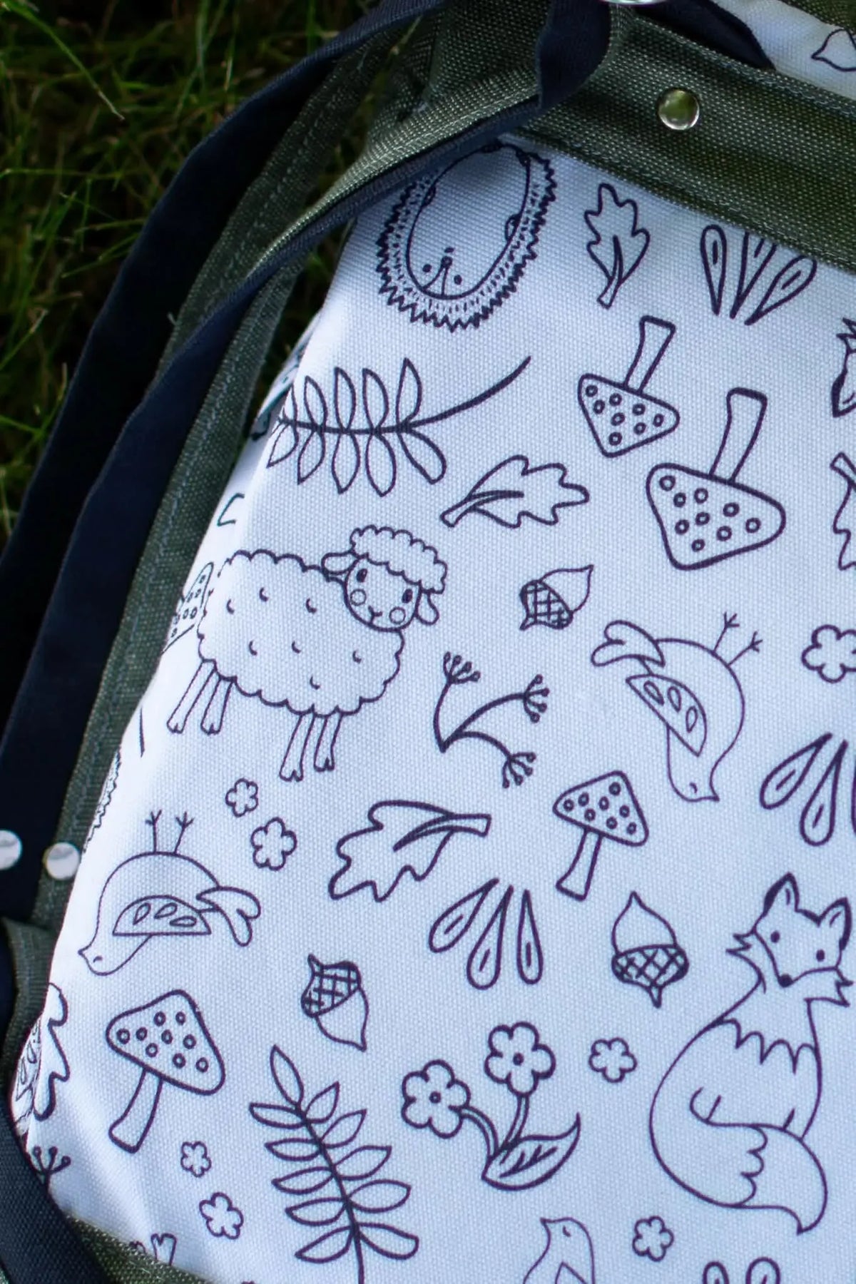 A white fabric panel with black outline drawings of woodland creatures.
