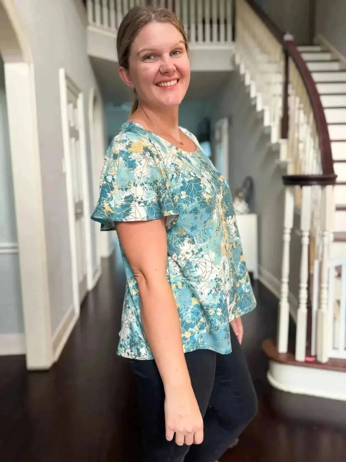 Teal gold abstract print fabric sewn into a woman's bell-sleeve top.