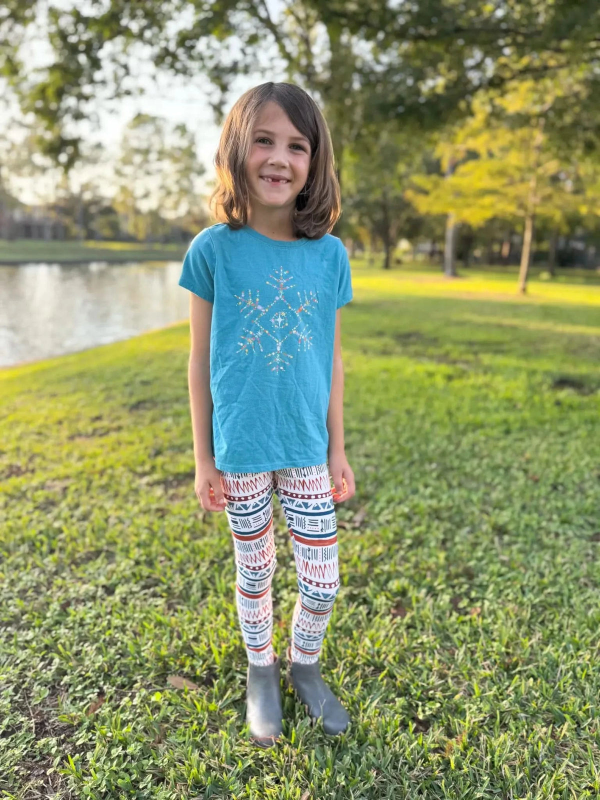 A young girl wears leggings with a red, white, and blue desert echo pattern.