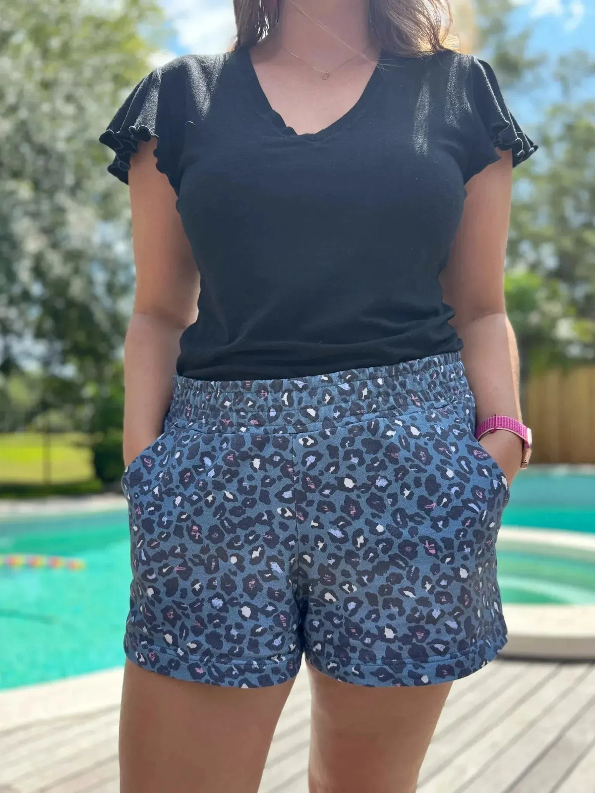 Teal leopard animal print fabric in summer design, shown as shorts with black top.