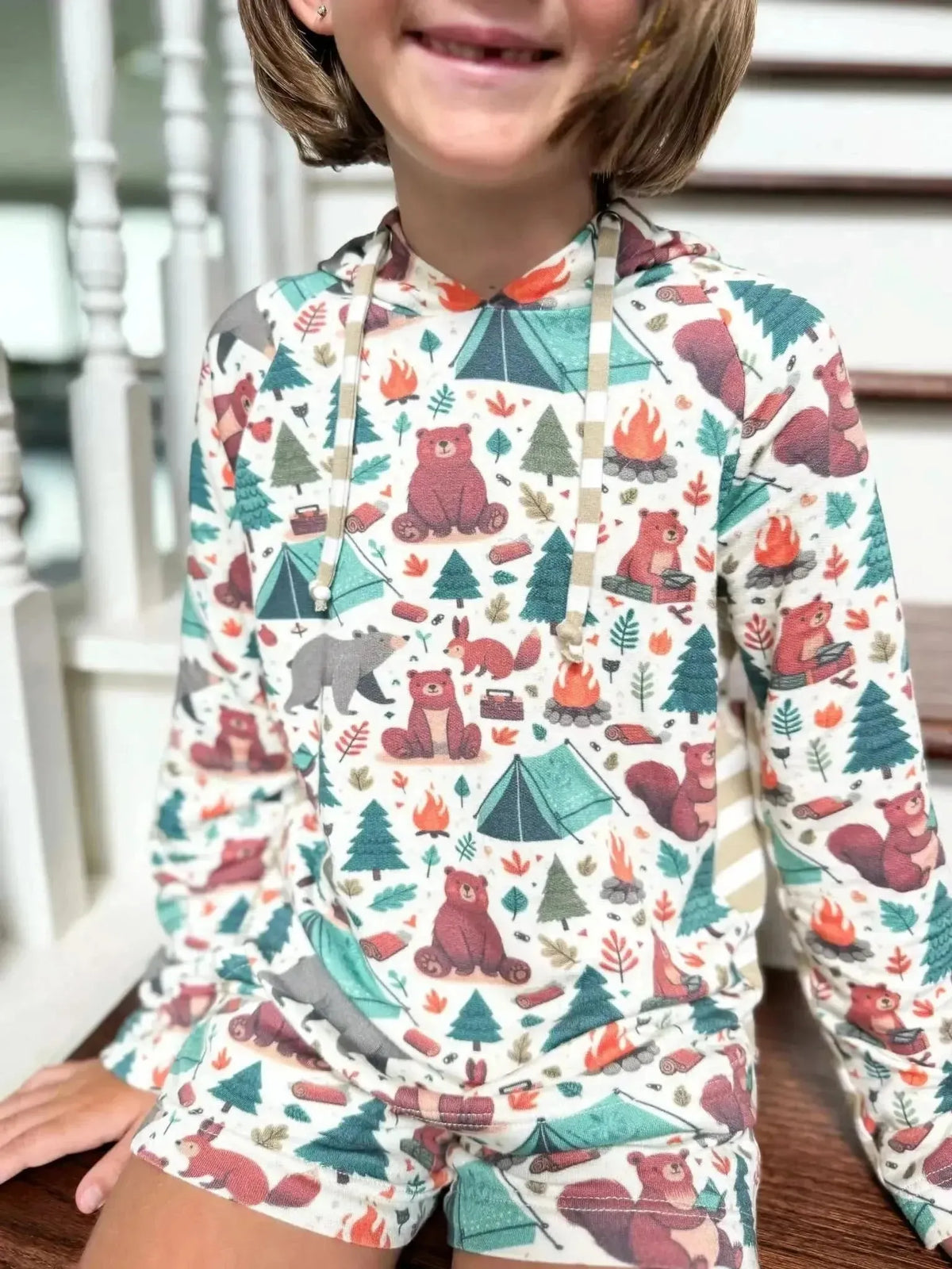 Fabric with woodland camping bears, tents, trees, and foxes in a colorful print.