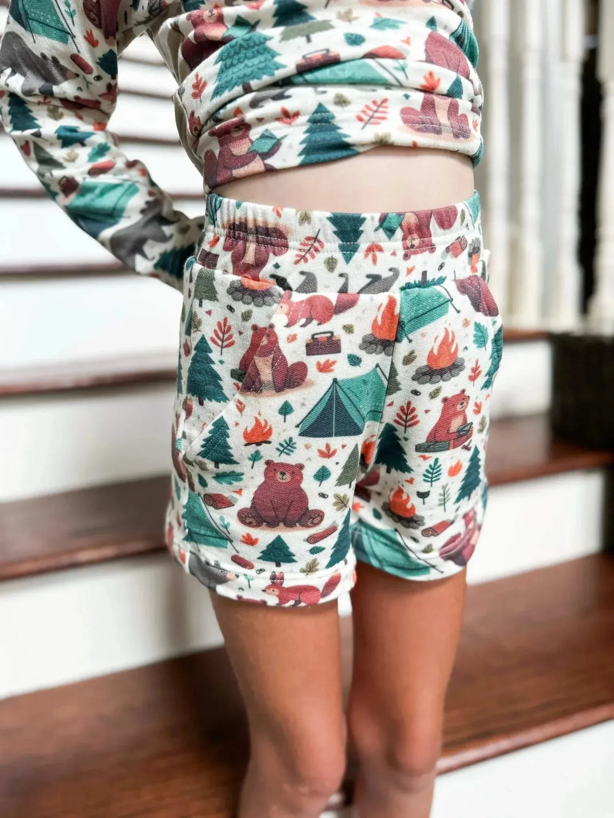 Girl modeling long-sleeve top and shorts in WayMaker Fabrics camping bears print.