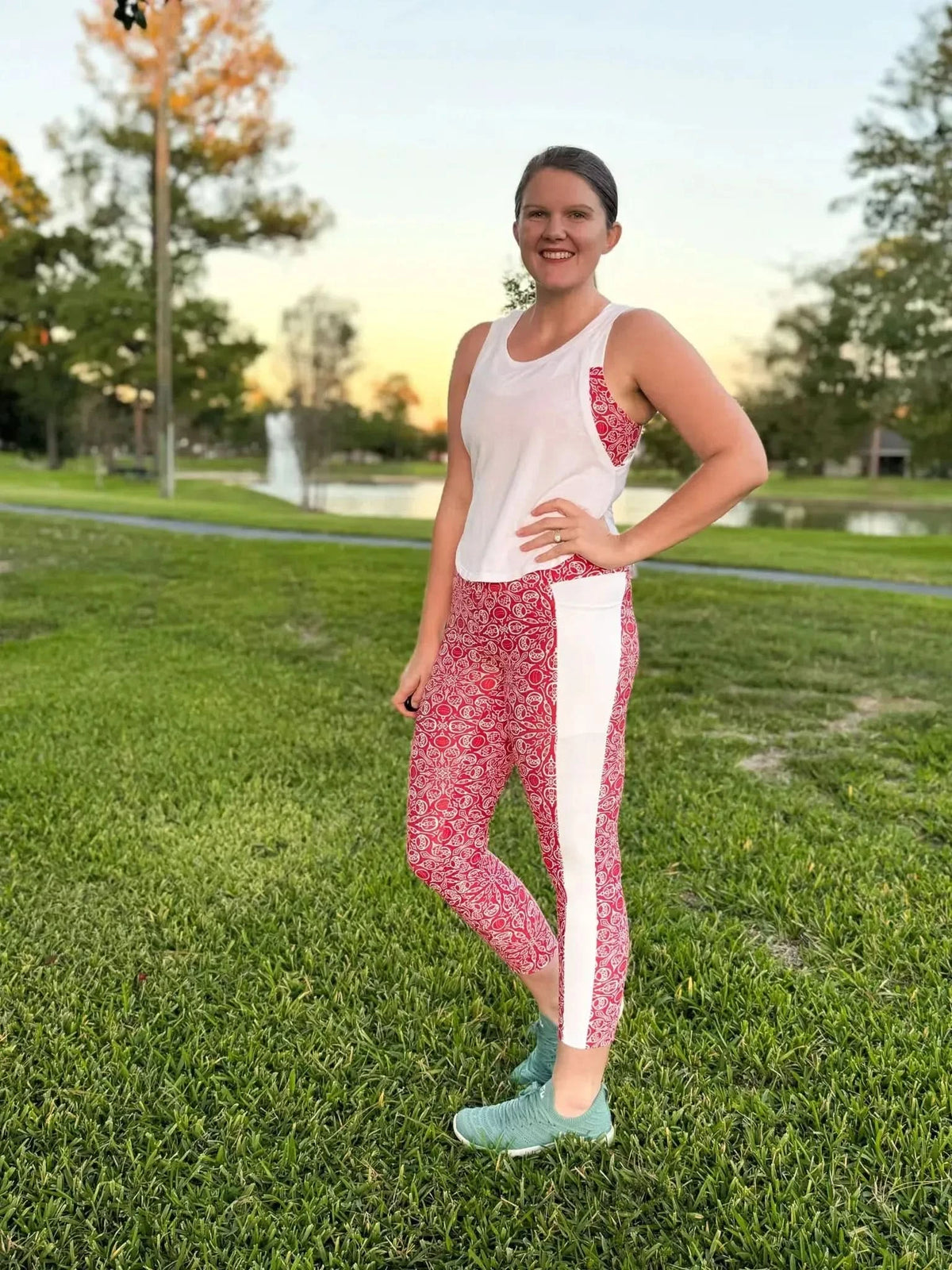 Woman in red and white patterned leggings and a white tank top.