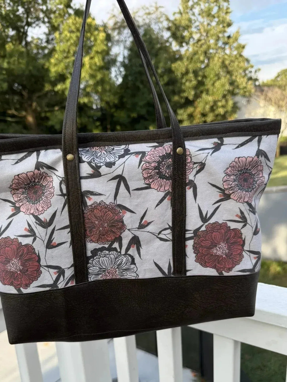 Close-up of Twilight Bramble Floral Fabric with pink flowers and bamboo on white base.