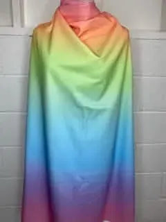 A long piece of fabric draped on a mannequin, featuring a rainbow ombre from pink to purple.