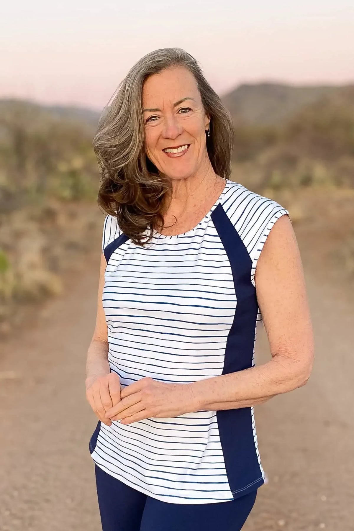 Woman in a navy and white striped top with solid navy side panels.
