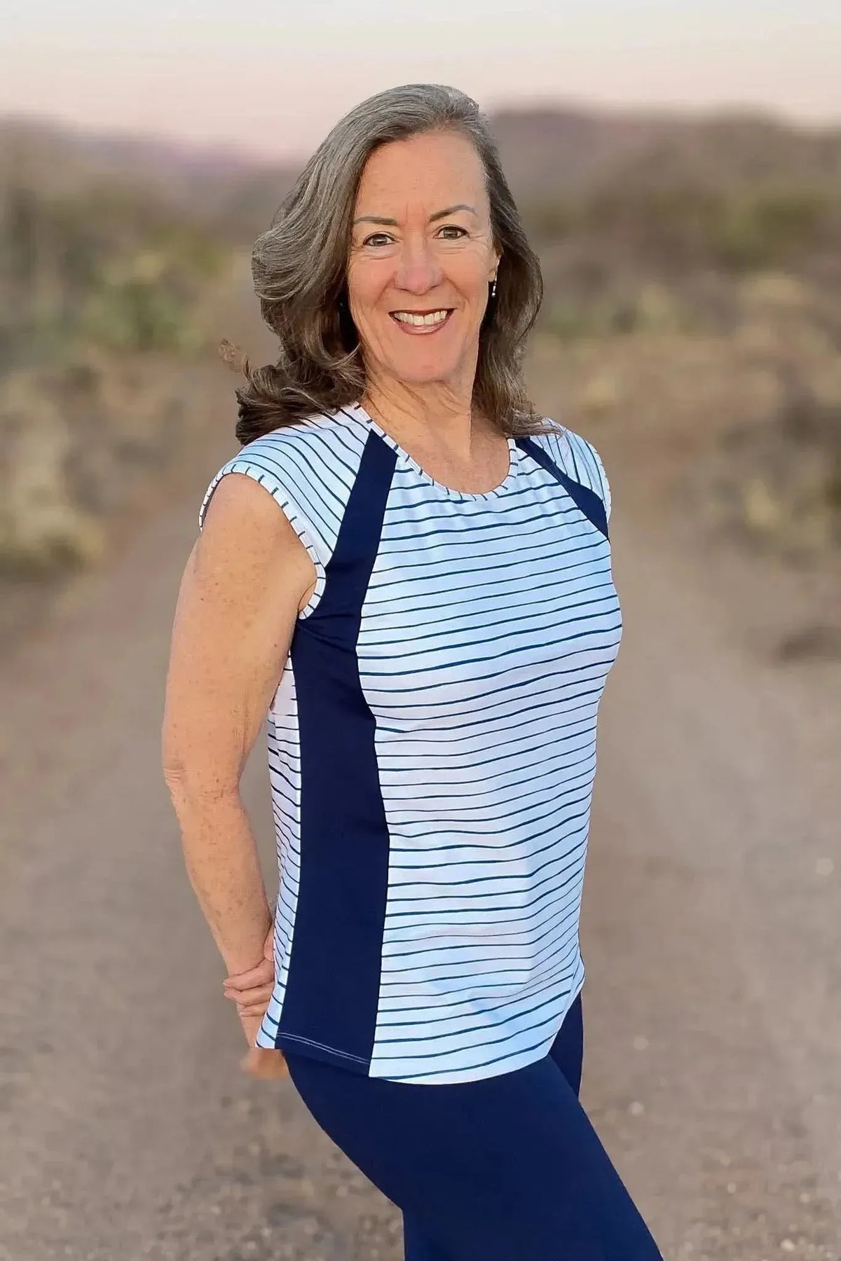 Woman modeling a navy and white striped sleeveless top and leggings made from stretchy fabric.
