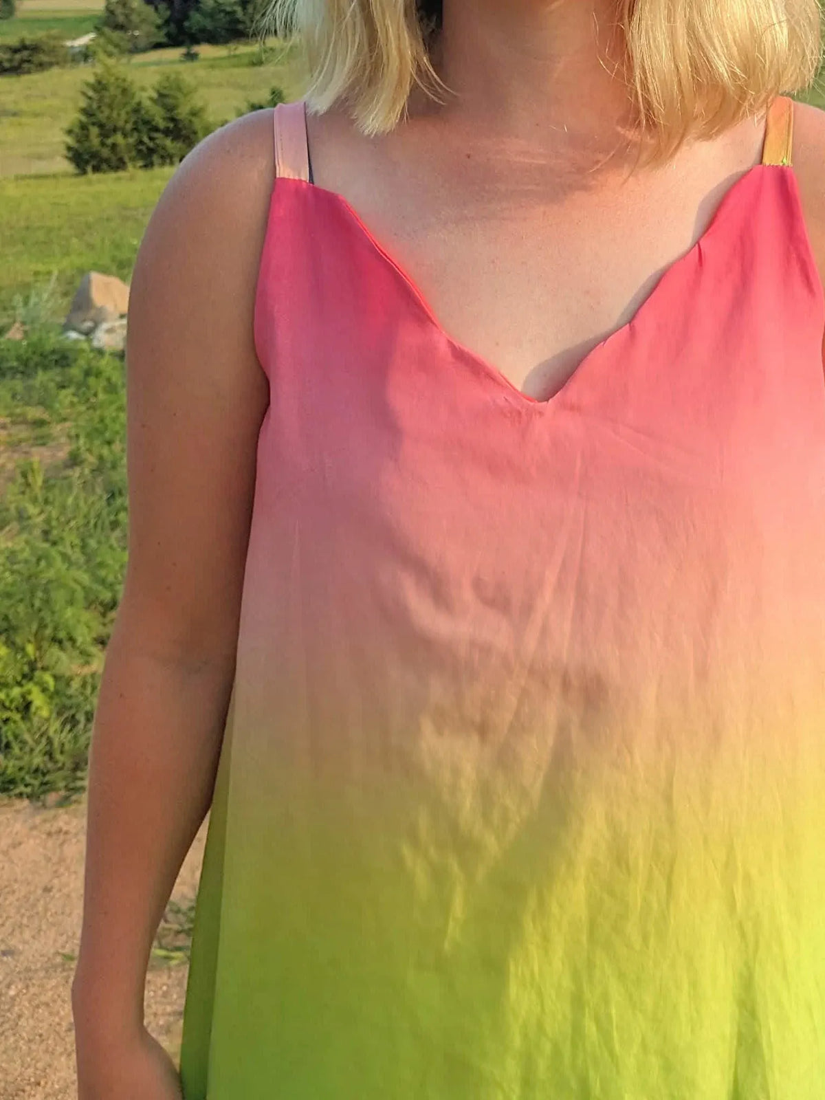 A woman wears a watermelon ombre top with pink fading to yellow-green.