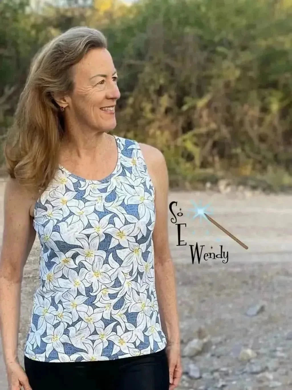 Blue fabric with white lily floral print, shown as a sleeveless tank top.