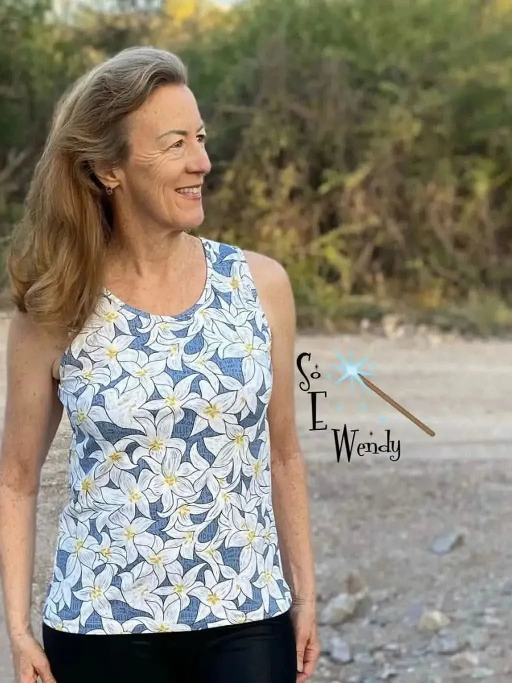 Blue fabric with white lily floral print, shown as a sleeveless tank top.