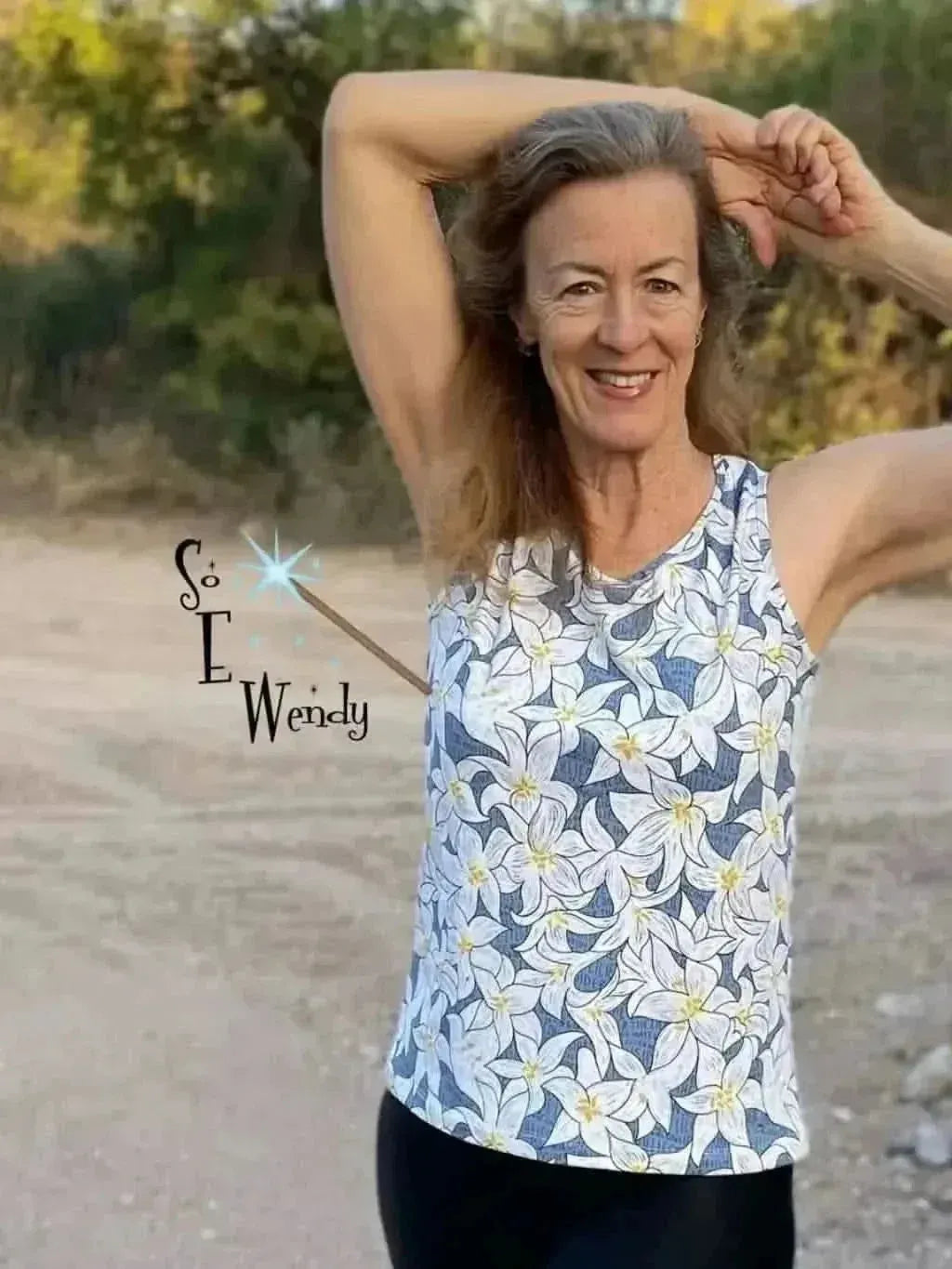 Woman wearing a blue lilies floral print tank top.