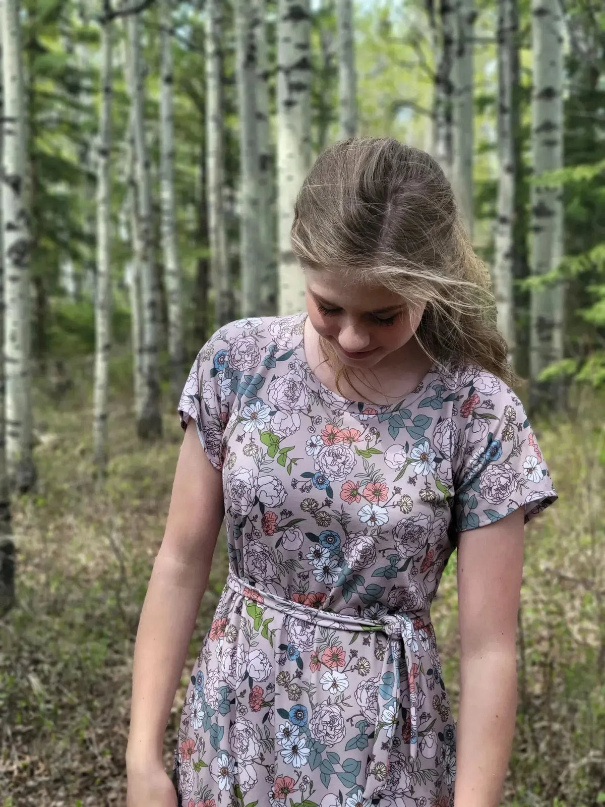 Tan Japanese floral fabric in a dress, modeled in a birch forest.