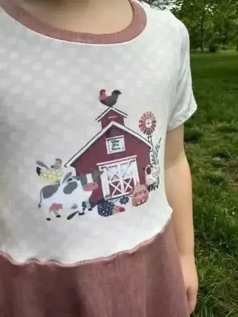 Farm-themed fabric panel with a red barn, cow, chicken, and pumpkins.