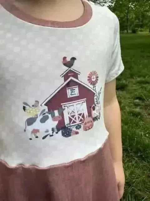 Farm-themed fabric panel with a red barn, cow, chicken, and pumpkins.