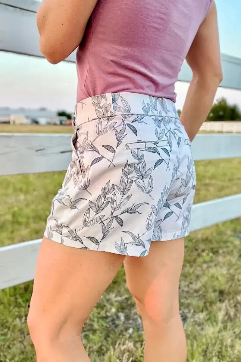 Grey foliage botanical print fabric with leaf motifs on a light background.