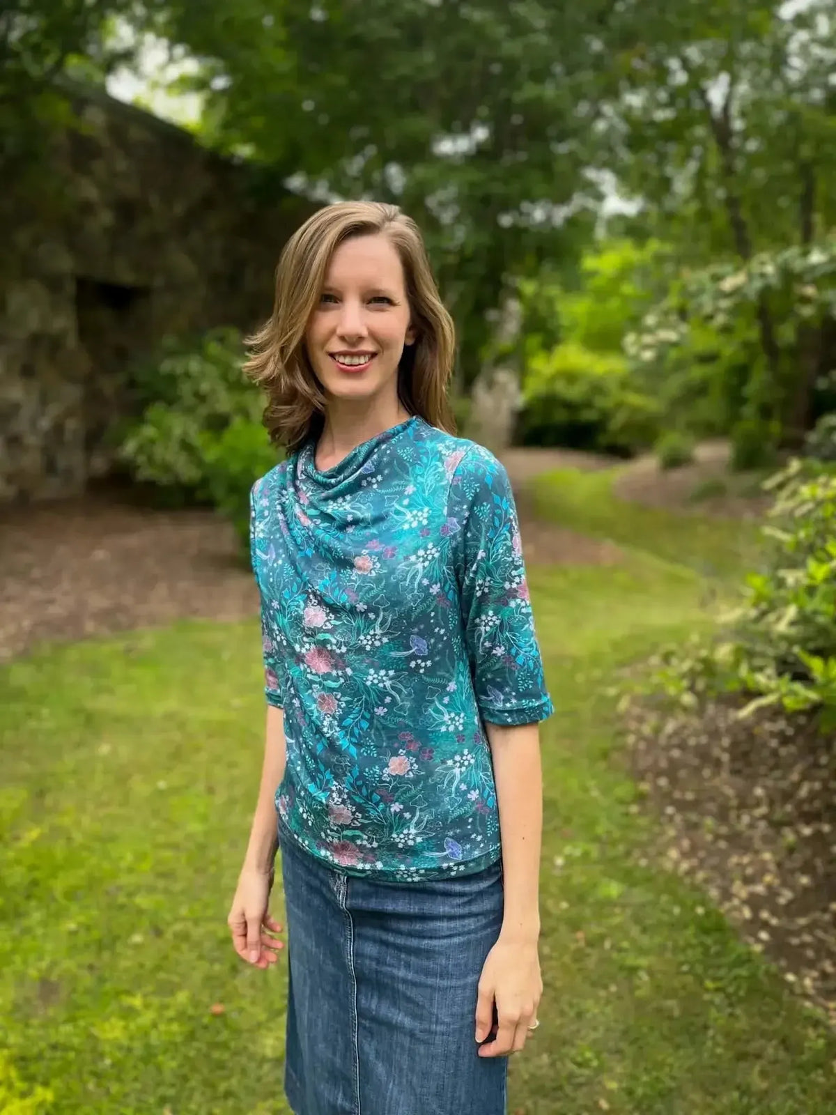 Teal woodland print fabric in enchanted glen pattern on a model wearing a draped top.