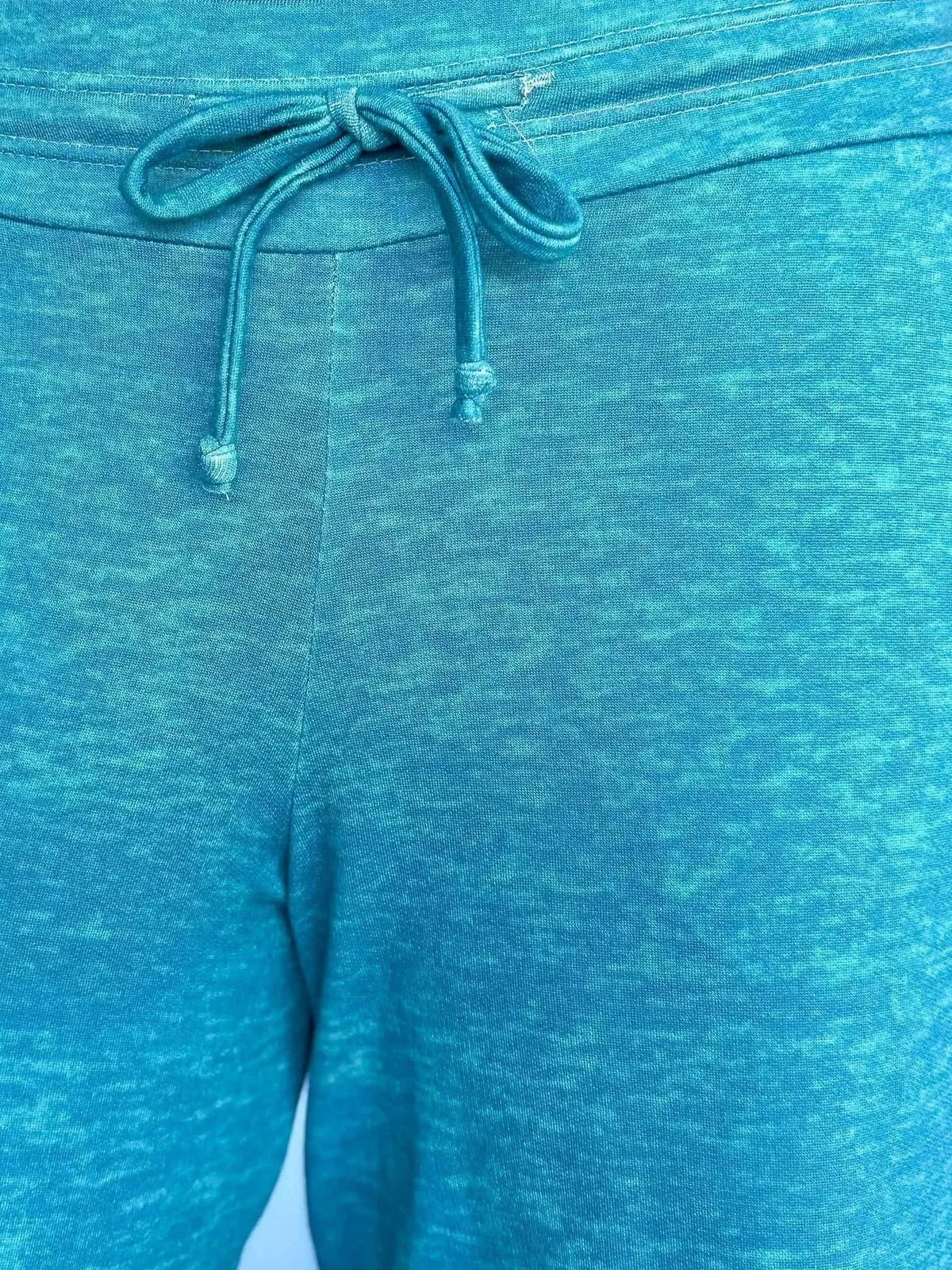 Close-up of dark teal heather fabric with a drawstring waist.