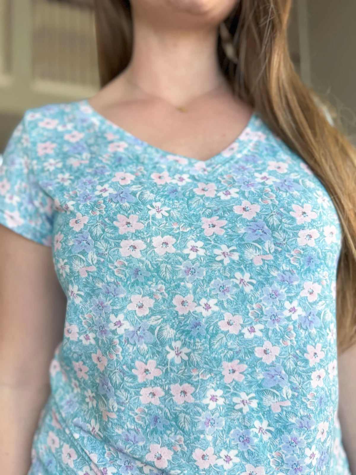 A person wearing a light blue floral print top.