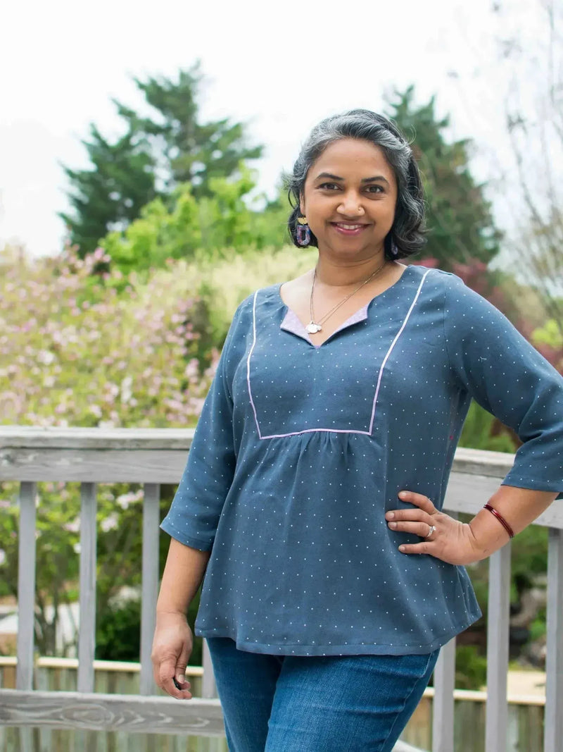 Navy polka dot patterned fabric swatch in a sewn garment on a model.