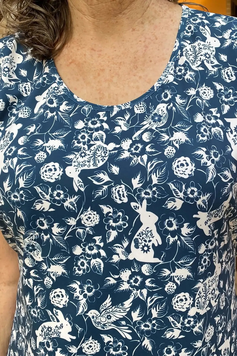 A person wearing a navy blue fabric with a white bunny and floral pattern.