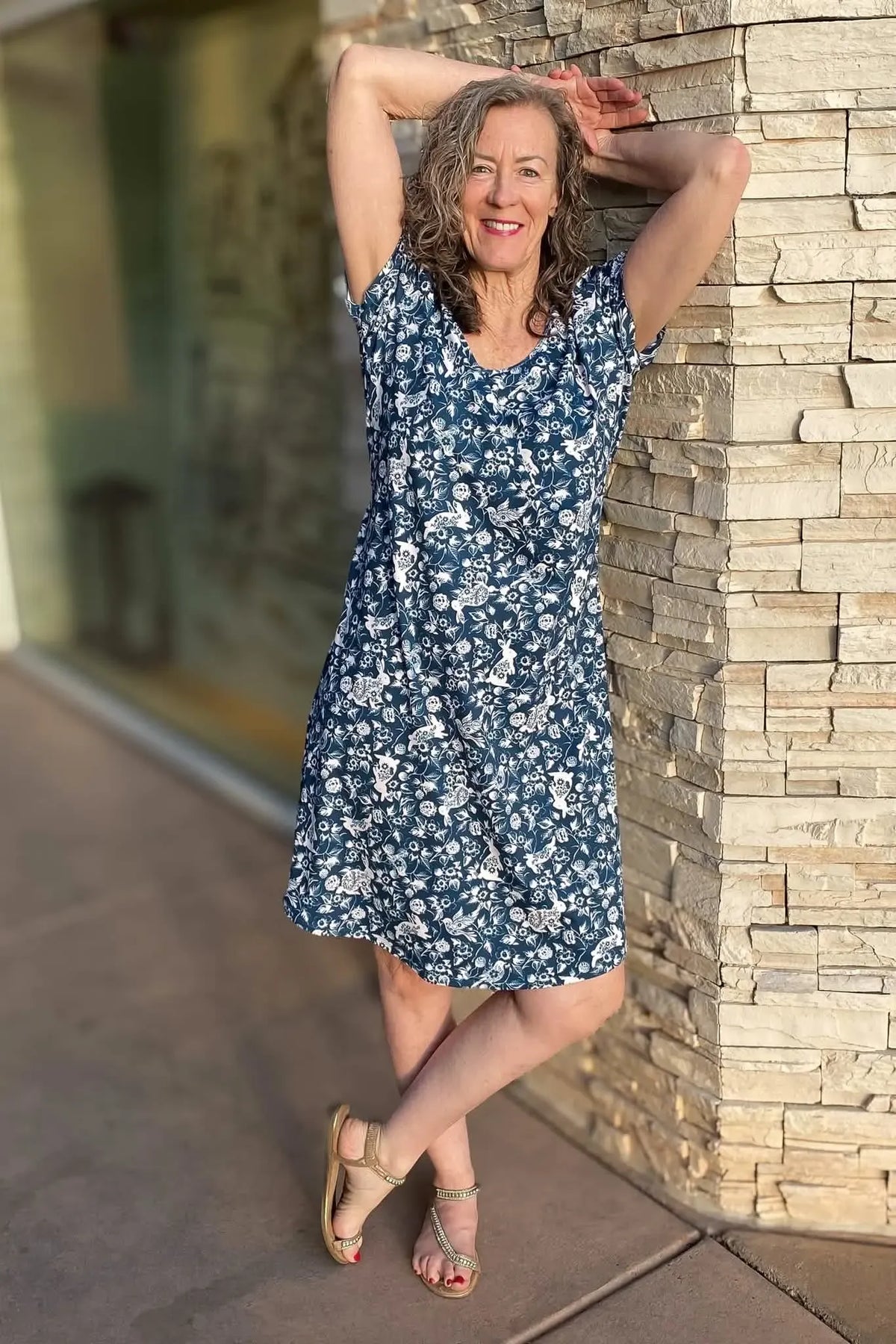 Woman in a navy blue dress with a white bunny and floral pattern.