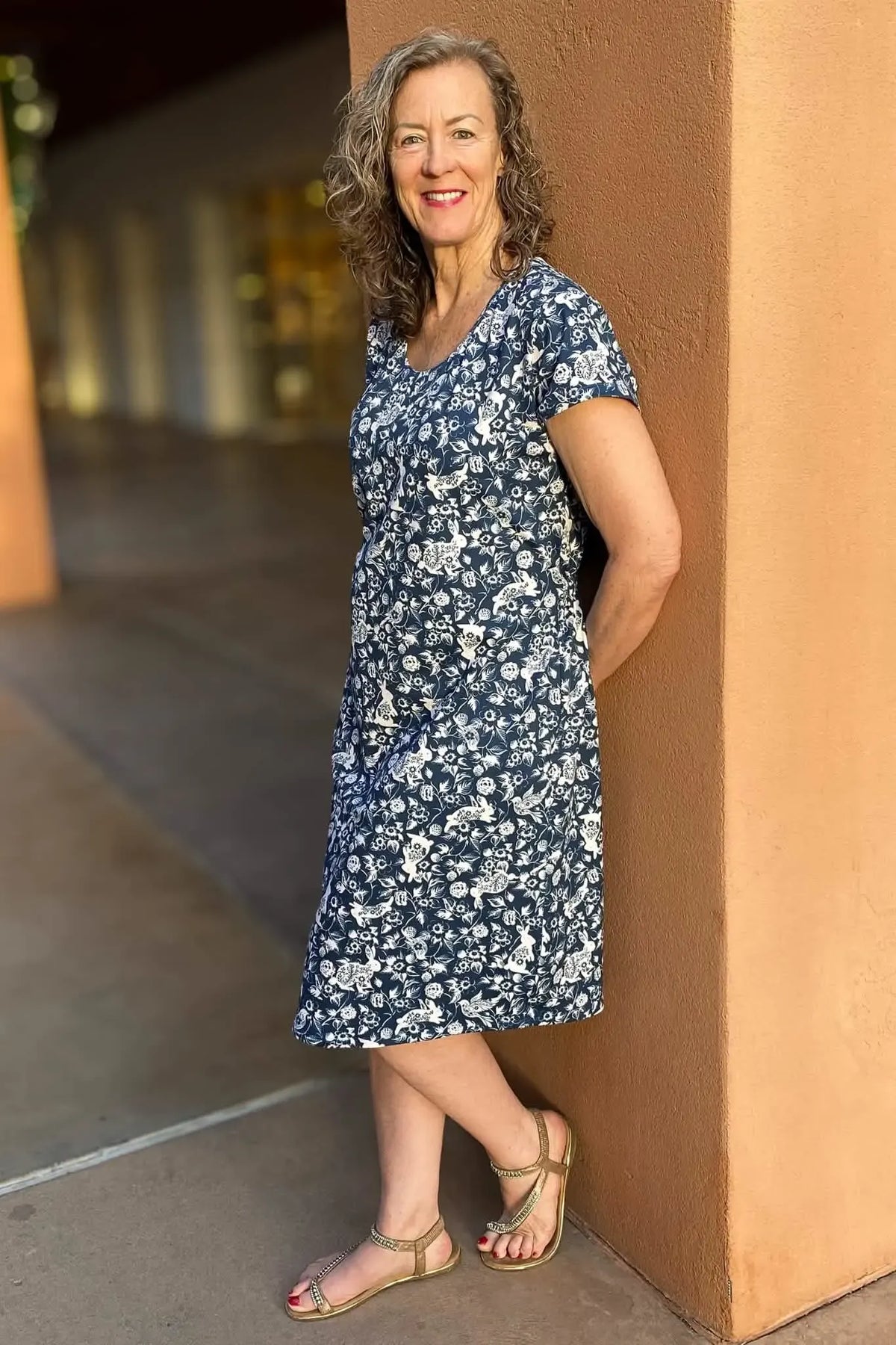 A woman in a navy dress with a white bunny and floral print.