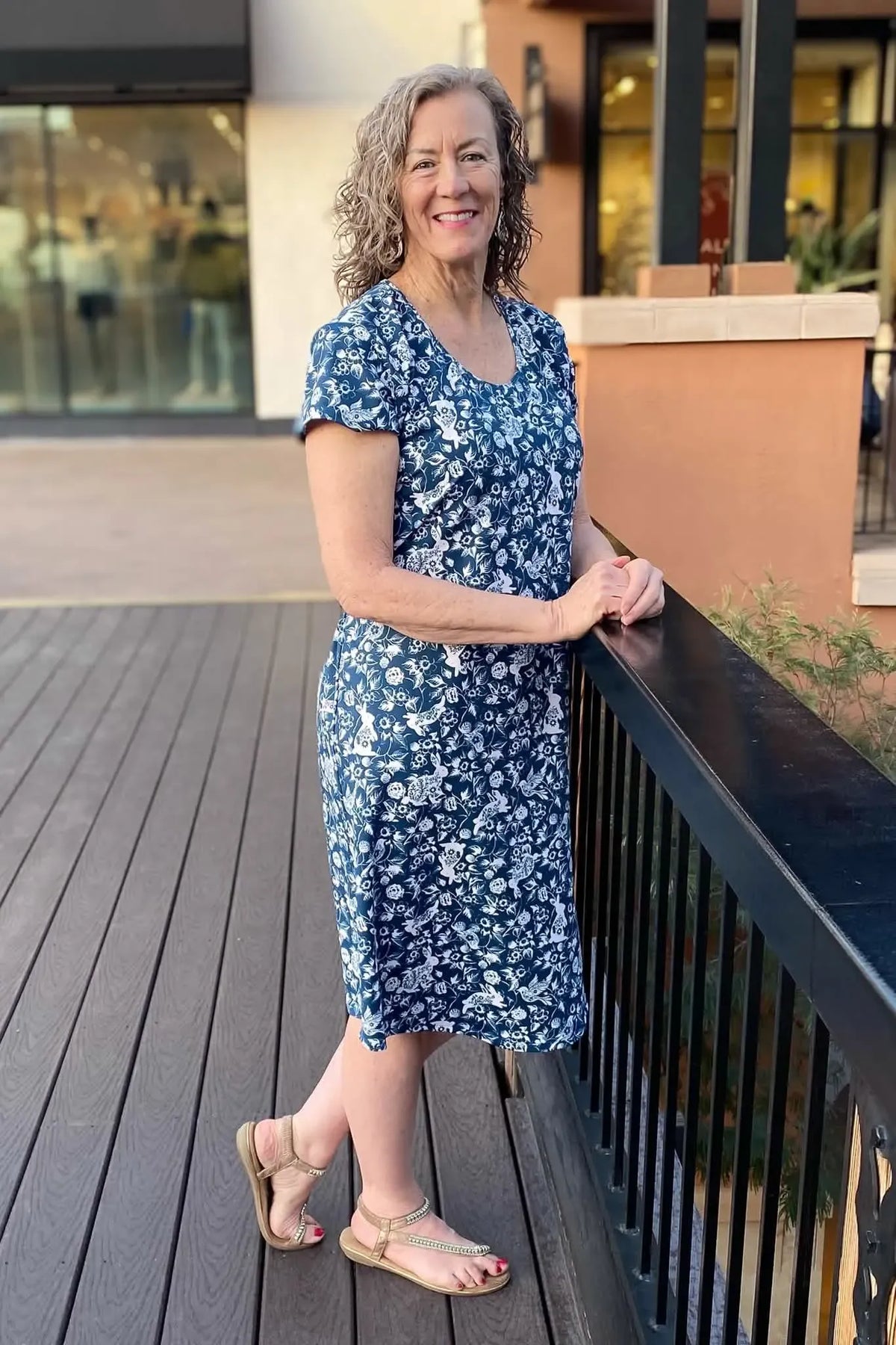 A woman in a navy blue dress with a white bunny and floral pattern.