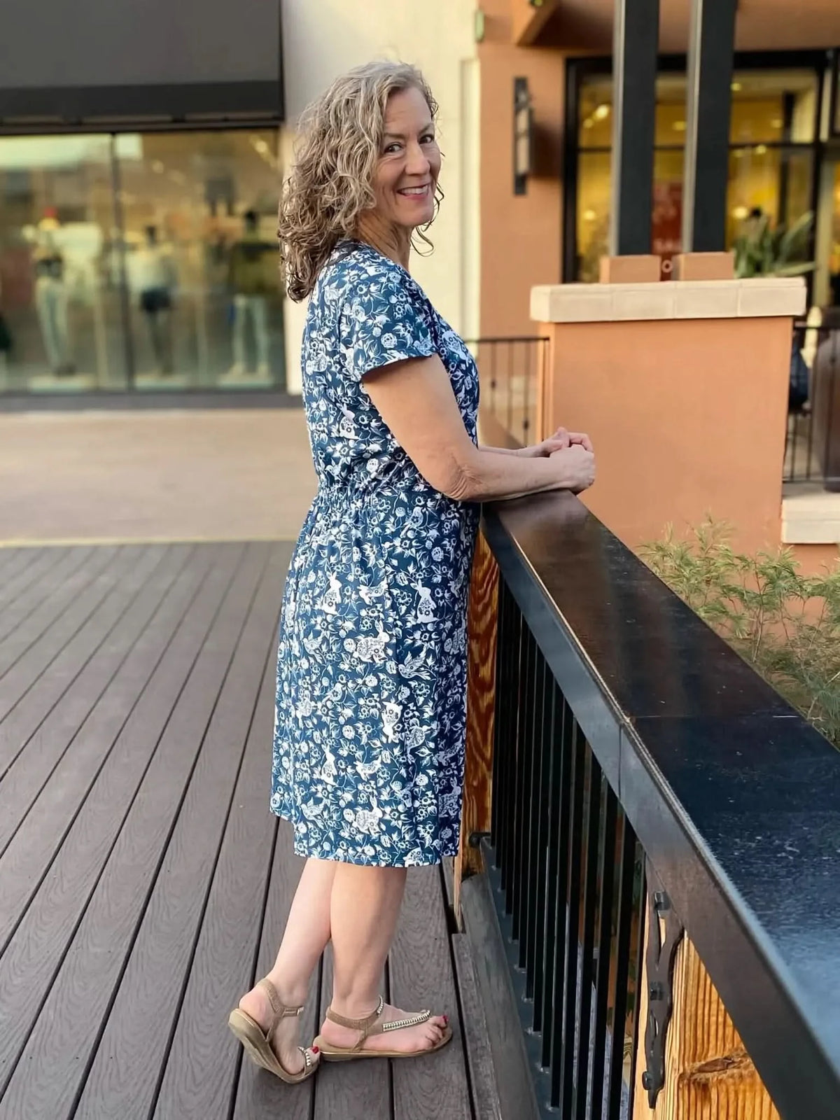 A woman in a navy dress with a white bunny and floral pattern.